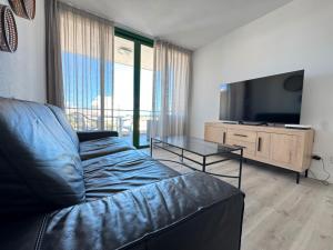 a living room with a couch and a flat screen tv at Espectacular Y Amplio Las Américas in Playa de las Americas