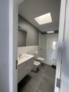 a bathroom with a white sink and a toilet at Espectacular Y Amplio Las Américas in Playa de las Americas