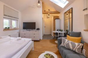 a living room with a couch and a tv at Nordseenest in Krummhörn +5 photos