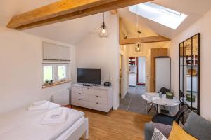 a living room with a couch and a tv and a table at Nordseenest in Krummhörn