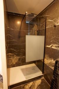a shower with a glass door in a bathroom at Instinct Sauvage - Nature & Jacuzzi privatif in Verdun