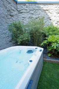 a jacuzzi tub in a garden next to a building at Instinct Sauvage - Nature & Jacuzzi privatif in Verdun