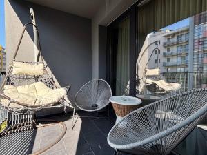 克卢日-纳波卡Sunflower Luxury Haven by Iulius Mall and FSEGA的大楼内的阳台配有椅子和吊床