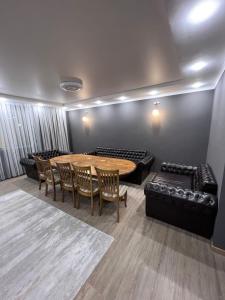 a room with a table and chairs and a couch at Охота in Bishkek +3 photos