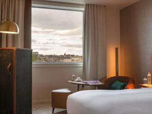 a hotel room with a bed and a window at Sofitel Luxembourg Le Grand Ducal in Luxembourg +186 photos
