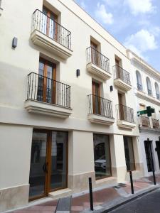 a white building with windows and balconies at El Jazmín del Patio in Nerja