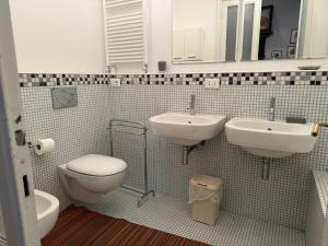 Un baño con dos lavabos y un inodoro. en palazzo piazza roma, en Chiavari 17 fotos más