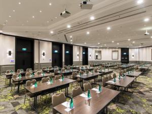 a large banquet hall with tables and chairs at Novotel Sydney International Airport in Sydney