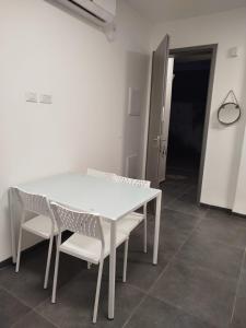 a white table and chairs in a room at Falkor's Nest in Atlit +3 photos