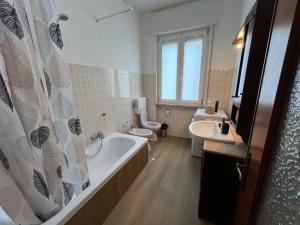 a bathroom with two toilets and a tub and a sink at GIODE X Borgo Roma II in Verona