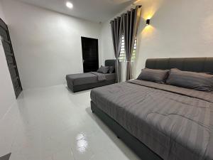une chambre avec un lit et un canapé dans l'établissement cheta roomstay, à Gua Sai