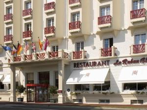 Una fachada de un hotel con banderas estadounidenses. en Hotel Mercure La Baule Majestic, en La Baule