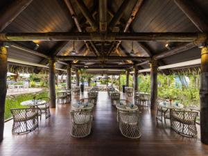 a restaurant with tables and chairs in a building at Sofitel Fiji Resort & Spa in Denarau