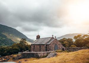 an old church on a hill with a church steeple at Buttermere Court Hotel in Buttermere +21 photos