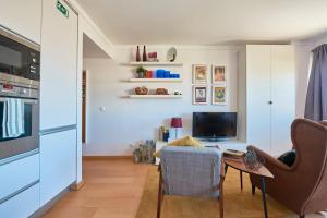 a living room with a table and a tv at Expo Studio in Lisbon