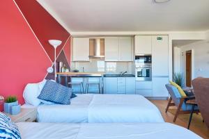 two beds in a room with a kitchen at Expo Studio in Lisbon
