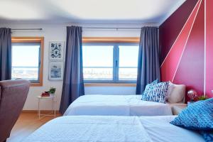 a bedroom with two beds and two windows at Expo Studio in Lisbon +36 photos
