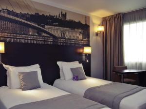 a hotel room with two beds and a window at Mercure Lyon Est Chaponnay in Chaponnay +105 photos