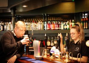 a man and a woman sitting at a bar at Buttermere Court Hotel in Buttermere