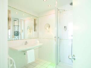 a bathroom with a sink and a shower at Mercure Limoges Centre in Limoges +44 photos
