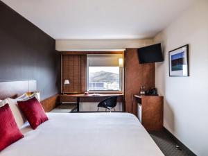 a hotel room with a large bed and a desk at Ibis Christchurch in Christchurch +29 photos