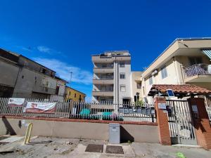 a fence in front of some buildings with a building at B&B Porta Roma in Capua