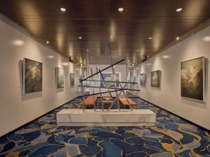 una exposición de museo con una escalera y pinturas en las paredes en Sofitel Brisbane Central, en Brisbane