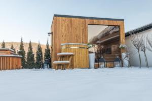 a couple of chairs in the snow next to a building at Willa Dream z basenem i jacuzzi 606-436-626 in Poronin