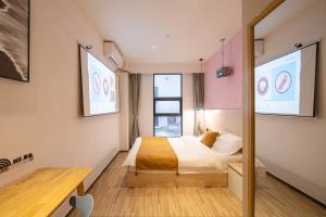 une chambre avec un lit, un bureau et une fenêtre dans l'établissement Tianhe Residence, Shanghai, à Shanghai