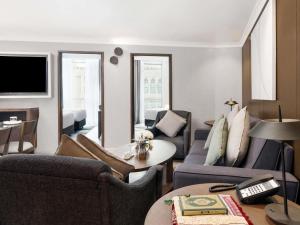 un salon avec un canapé, des chaises et une télévision dans l'établissement ZamZam Pullman Makkah, à La Mecque