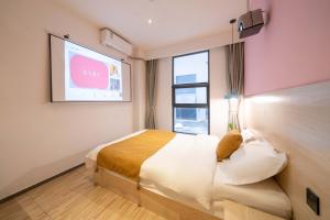 - une chambre avec un lit et une fenêtre avec un paravent dans l'établissement Tianhe Residence, Shanghai, à Shanghai