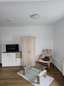 a living room with a glass coffee table and a chair at Ferienwohnung Hohenstaufen in Göppingen