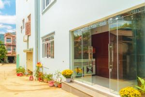 a glass door of a building with potted plants at Phuong Linh Hotel in Bảo Lạc