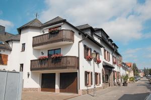 un edificio bianco con balconi e fiori di Weinhotel Offenstein Erben a Eltville