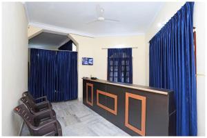 Una sala de espera con cortinas azules y un escritorio y sillas. en HOTEL PINK-Villa Near Budha Jayanti Park- with free wifi - Restaurant Facilities Available - Best Hotel In Bhubneshwar, en Cuttack