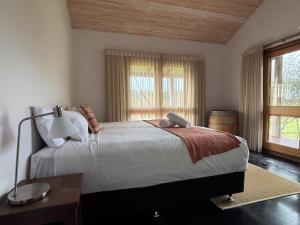 a bedroom with a large bed with a lamp and a table at Valley Cottage, Treeton winery, Margaret River in Cowaramup