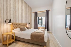 a bedroom with a large bed and a mirror at Tanoeiros Residence by An Island Apart in Funchal