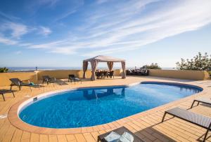 uma piscina com cadeiras e um gazebo em Villa Panoramica em Estoi