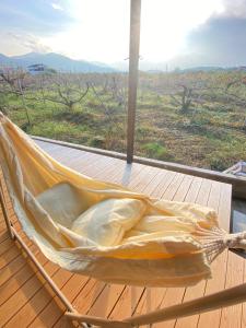 un hamac sur une terrasse avec vue sur un champ dans l'établissement 柿畑の宿 Private stay with farm and house all to yourself, à Katsuragi