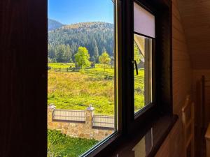 an open window with a view of a field at Котедж Маєток Ярини in Krivopolʼye