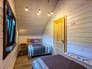 a bedroom with two beds in a wooden room at Котедж Маєток Ярини in Krivopolʼye +29 photos
