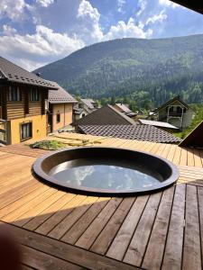 a circular pool on a wooden deck with a mountain at Котедж Маєток Ярини in Krivopolʼye