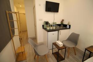 Una pequeña habitación con un mostrador y dos sillas y una mesa. en AMD Hotel Modern Comfort in the Heart of Sutton SM1, en Sutton