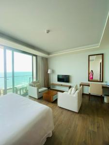 a hotel room with a large bed and a large window at Premium Apartment, Balcony Ocean View,Infinity Pool, 01 Min To My Khe Beach, PickUp Managed by Ala Carte Da Nang in Da Nang