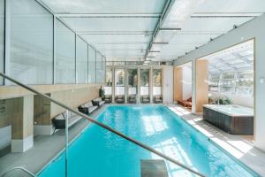 an indoor swimming pool with a large window and a tub at Hotel Sinaia in Sinaia +44 photos