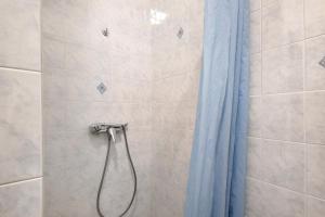 a shower with a blue shower curtain in a bathroom at Maison de village Le Galbe in La Llagonne +17 photos