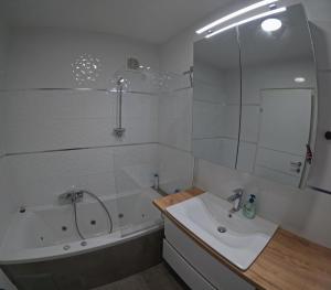 a bathroom with a tub and a sink and a shower at Alpine Oasis in Hermagor +19 photos