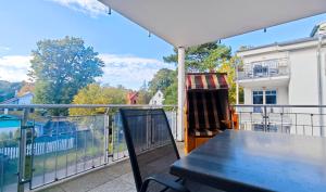a balcony with a table and a chair on it at Ostseestrand in Juliusruh
