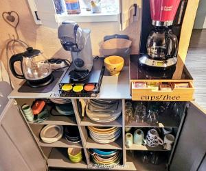 a cupboard filled with dishes and a coffee maker at Logeerboerderijtje De Rietkap Gieten in Gieten +50 photos