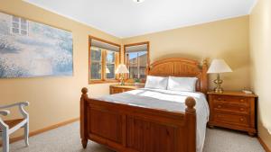 a bedroom with a wooden bed and a window at Seacliff Haven Waterfront Luxury Stunning Views Hot Tub Game Room in Coupeville +41 photos